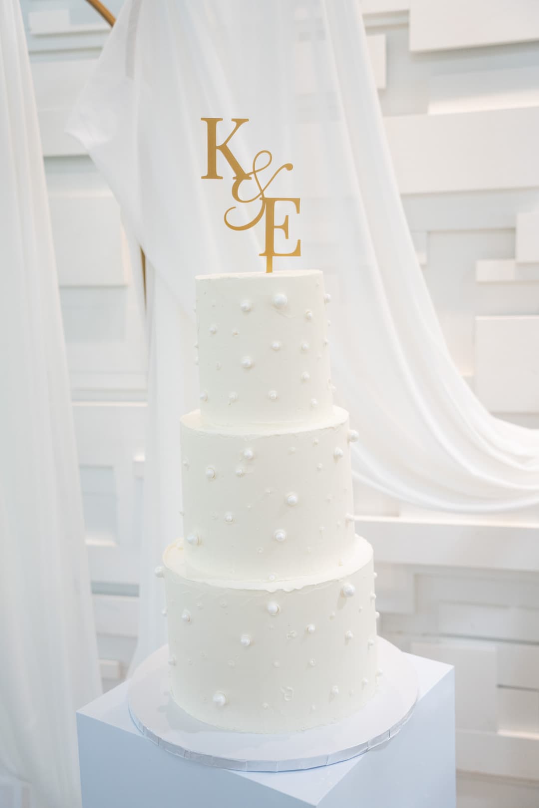 Beautiful faux wedding cake by @deliciousdrizzle with our rental backdrop and drapery