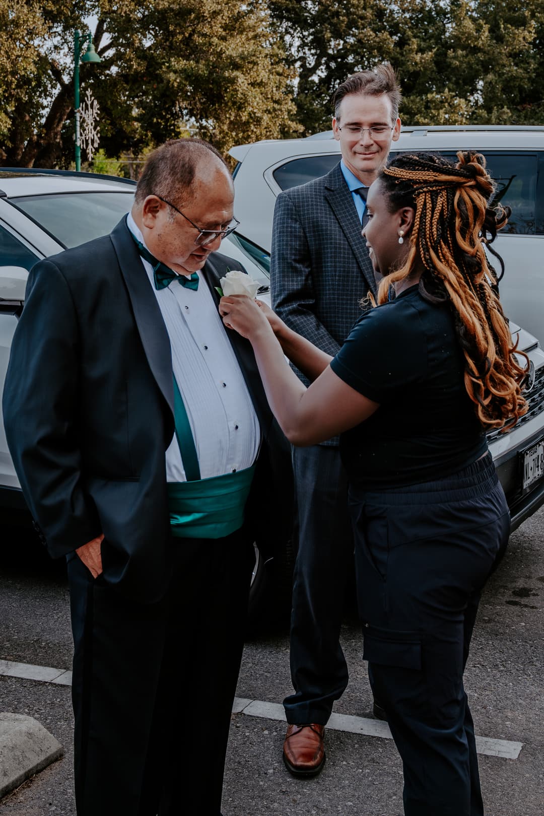 Wedding Planner pinning boutonniere on Grandfather of Bride