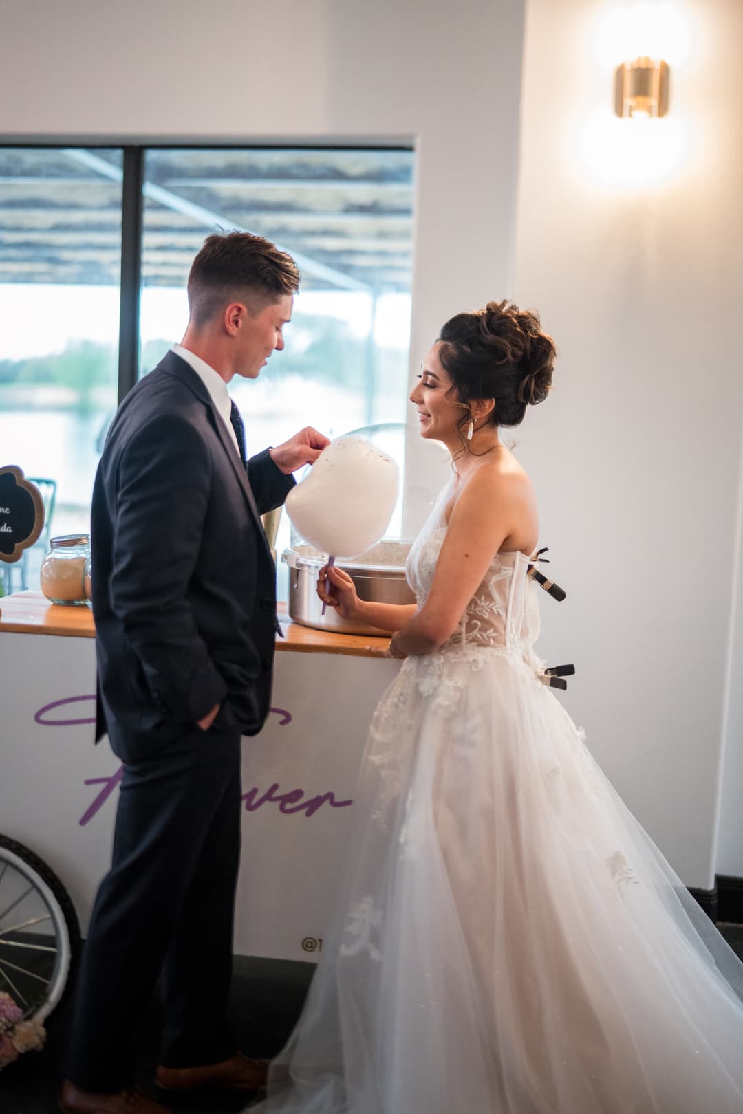 Bride & Groom Posing with Tasty Swirls Cotton Candy Cart